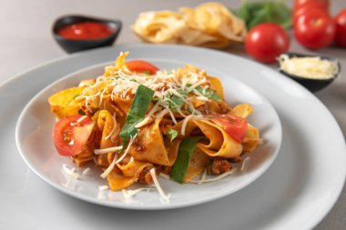 Siyah kasede sığır eti soslu makarna. Gri arka plan. Kapat.