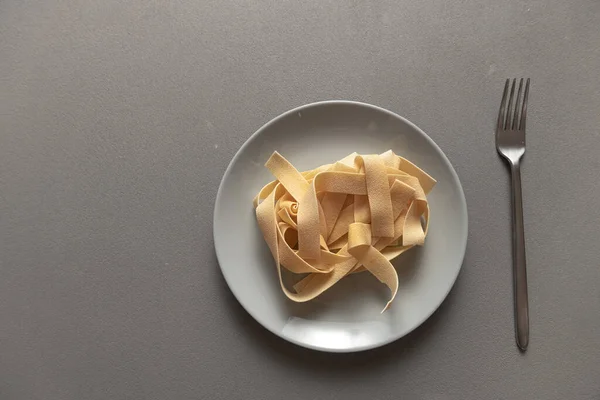 Rohe Italienische Pasta Auf Einem Grauen Teller Vor Grauem Hintergrund — Stockfoto