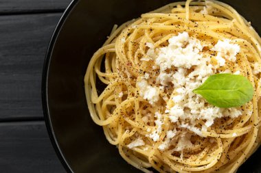 Cacio e Pepe - Peynirli İtalyan Makarnası ve Kara Arkaplanda Siyah Tabakta Pepper. Üst Görünüm ve Kapat