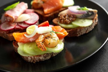 Smorrebrod, geleneksel Danimarka sandiviçleri koyu tabakta. Kara Tabakta Büyük El Yapımı Sandviç