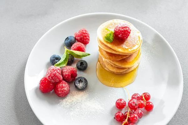 Food for breakfast healthy eating. Pancakes with honey. Homemade pancakes on a white background. European breakfast pancakes and berries. Pancakes without butter with berries. Food for vegetarians and