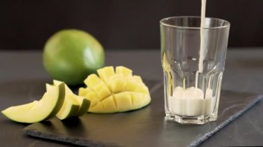 Klasik bir Hint Lassi içkisi. Mangolu milkshake. İçki bir bardağa doldurulur. Lassi milkshake yapma süreci. Cam kavanoza mangolu yoğurt koyuyorsun.