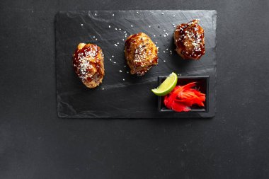 Siyah arka planda tavuklu teriyaki. Yeni bir başlangıç için Asya yemeği. Teriyaki tavuğu, Japon mutfağında yaygın olarak kullanılan geleneksel bir Japon kızartma metodudur. Tavuk teriyaki bir klasiktir.