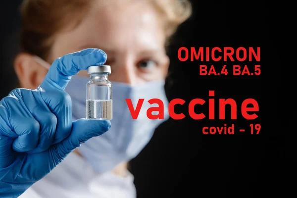 A female doctor wearing a medical mask and protective medical gloves holds a vaccine tube. Omicron COVID-19 variant and corona virus vaccine, focus on vaccine vial. Concept of health, new coronavirus