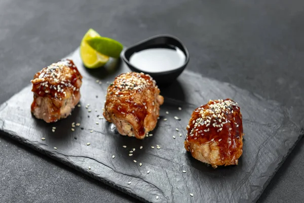 teriyaki chicken on a slate with sesame seeds. Asian Cuisine. Asian food. Fast food street food. Chicken in teriyaki sauce and sesame. a traditional Japanese way of frying using a common sweet sauce