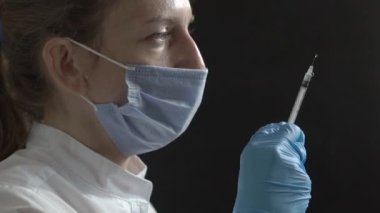 the doctor squirts the vaccine from a syringe. The doctor makes sure there is no air in the syringe. Doctors job
