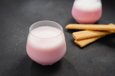 A cup of hot beet coffee latte on a light wooden background. A trendy, healthy drink. A cup with a beet-based drink. An alternative to coffee, giving up coffee. Beet Latte.
