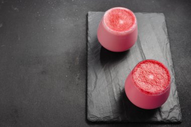 An alternative to caffeine. Beet latte on a dark background. Top view and copy space