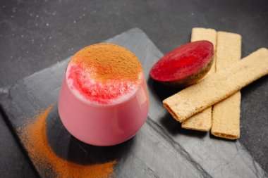 A cup of hot beet coffee latte on a light wooden background. A trendy, healthy drink. A cup with a beet-based drink. An alternative to coffee, giving up coffee. Beet Latte.