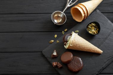 The process of making homemade ice cream on a black background. Ingredients for making ice cream on a wooden background.