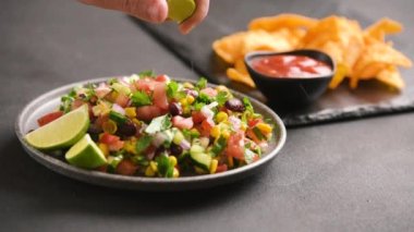 Teksas havyar salatası pişiriyorum. Teksas salsası limon suyuyla ıslatılmış. Teksas havyarı yapma süreci. Bir adamın eli limonu eziyor. Amerikan Kültür Latin Amerikan Yemekleri. Redüktör