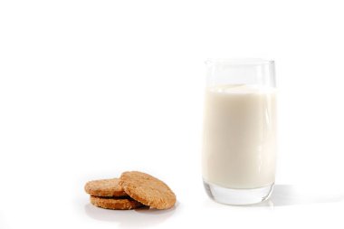 Beyaz arka planda bir bardak sütle kurabiyeler.