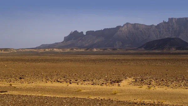 Las rocas removidas inusuales entre la arena. Desierto libio. Polvo de oro denso, dunas y hermosas estructuras arenosas a la luz del sol bajo . — Foto de Stock