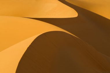 Libya çöl. yoğun altın tozu, tepeleri ve düşük güneş ışığında güzel kumlu yapıları.