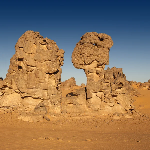 Las rocas removidas inusuales entre la arena. Desierto libio. Polvo de oro denso, dunas y hermosas estructuras arenosas a la luz del sol bajo . — Foto de Stock