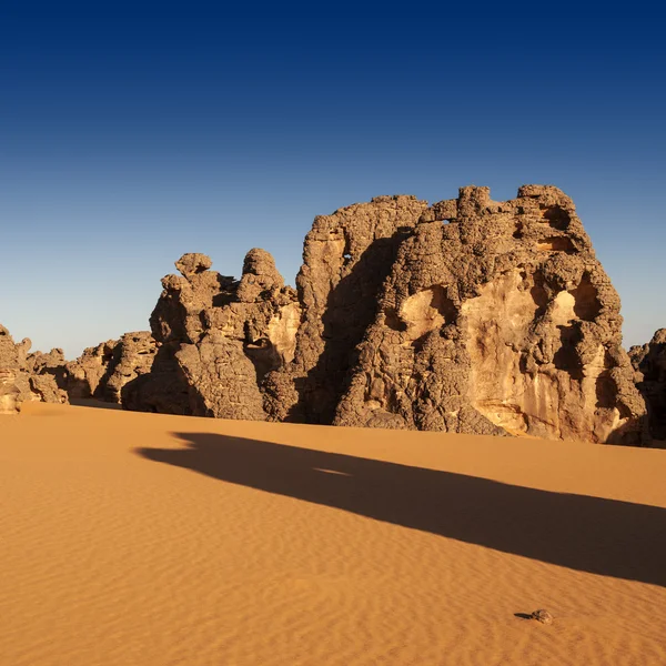 As rochas removidas excepcionais entre areia. Deserto Líbio. Poeira de ouro densa, dunas e belas estruturas arenosas à luz do sol baixo . — Fotografia de Stock