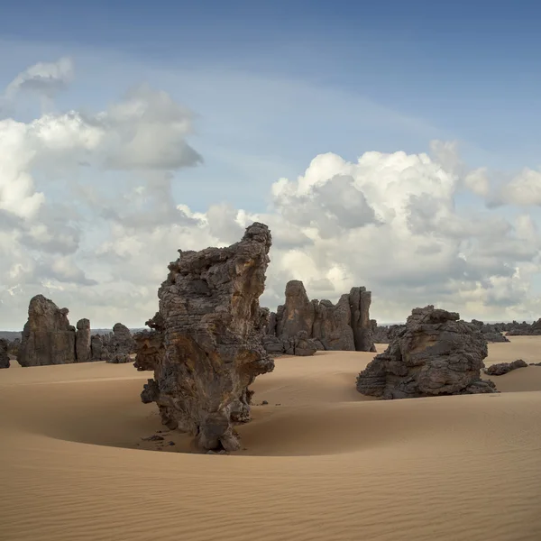 Las rocas removidas inusuales entre la arena. Desierto libio. Polvo de oro denso, dunas y hermosas estructuras arenosas a la luz del sol bajo . — Foto de Stock