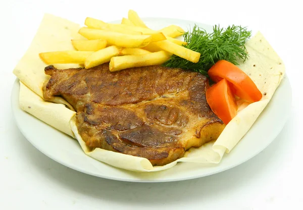 Patatesli, domatesli ve yeşillikli domuz madalyonu.