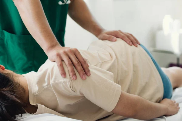 Doktor ya da fizyoterapist genç bir kadının sırtını iyileştirir. Rehabilitasyon merkezinde de tavsiye verin. Fiziksel rehabilitasyon kavramı.
