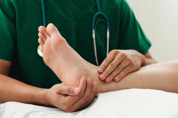 Modern kliniklerde yaralı ayak bileği ağrısını tedavi eden bir fizyoterapist. Fiziksel rehabilitasyon kavramı..