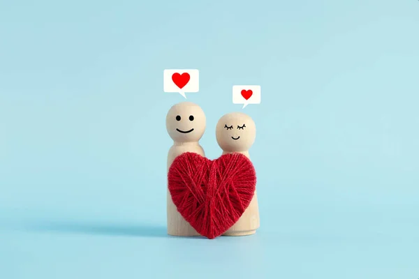 明るい青の背景に描かれた笑顔を持つ愛の幸せなカップルの木製人形 バレンタインデー ストック画像