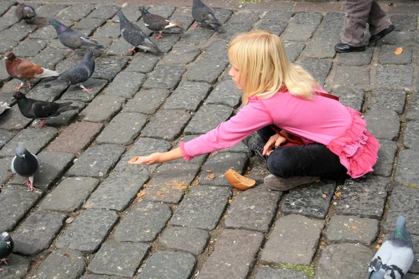 Ragazza che nutre piccioni — Foto Stock