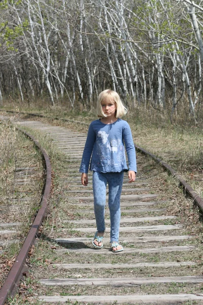 Ung blond jente på jernbanespor – stockfoto