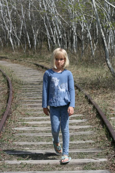 Ung flicka promenader längs järnvägsspår — Stockfoto