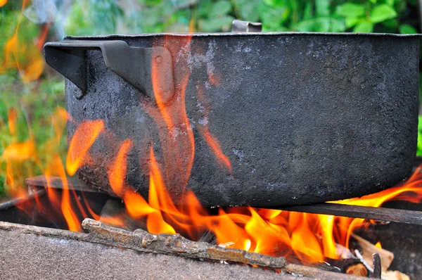 Preparing food on a fire in marching conditions — Stock Photo, Image
