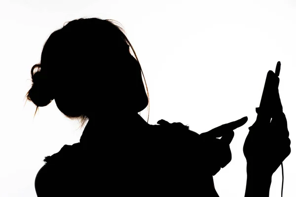 Siluet Profilde Bir Kız Cep Telefonu Tutuyor Kulaklıkla Müzik Dinliyor — Stok fotoğraf