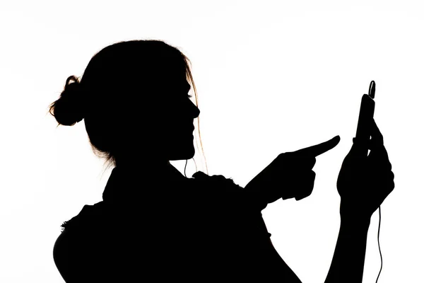 Siluet Profilde Bir Kız Cep Telefonu Tutuyor Kulaklıkla Müzik Dinliyor — Stok fotoğraf