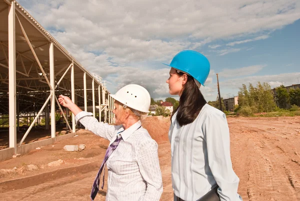 Twee ingenieurs op de bouwplaats Stockafbeelding