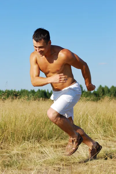 Atletisk man kör i utomhus scen — Stockfoto