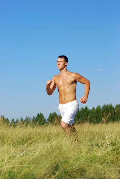 Hombre atlético corriendo en escena al aire libre — Foto de Stock