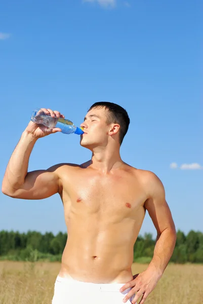 Молодий чоловік п'є воду після тренування — стокове фото
