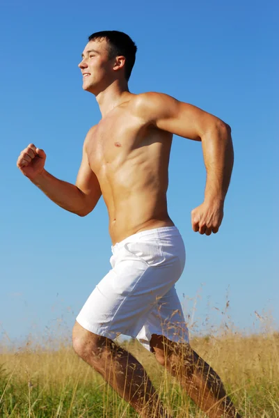 Sportlicher Mann läuft in Outdoor-Szene Stockbild