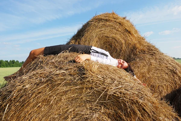 Vrouw op hooi Baal in zomer veld — Stockfoto