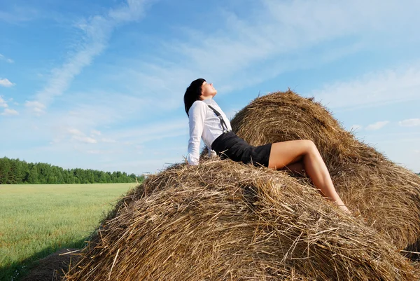 Woman on hay bale in summer field — Stock Photo, Image