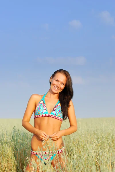 Mladá žena na pšeničném poli — Stock fotografie