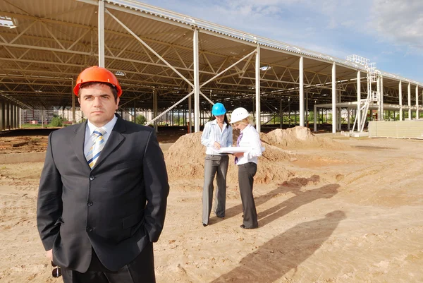 Direktor mit Untergebenen auf Baustelle Stockbild