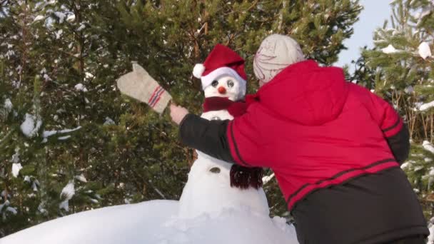 Vrouw maken sneeuwpop — Stockvideo