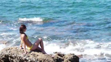 kayaların üzerinde oturan genç çekici kadın