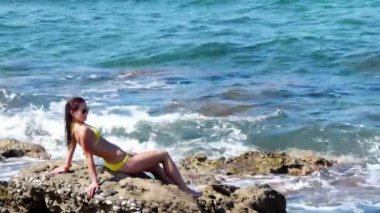 kayaların üzerinde oturan genç çekici kadın