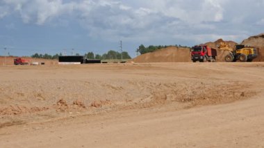 VELIKIE LUKI, PSKOV REGION, RUSSIA - 01 Ağustos 2021: Et işleme tesisinin inşaat sahasının dengelenmesi için toprak taşıyan roketlerin video çekimi