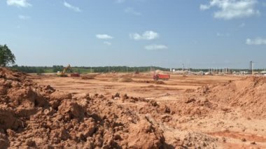 Et işleme tesisinin inşaat alanını dengelemek için toprak taşıyan kargaşaların video görüntüleri.
