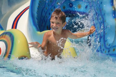 Açık eğlenceli aquapark içinde olan genç gülümseyen çocuk portresi