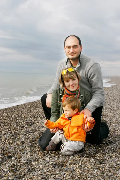 Unga lyckliga familjen på stranden — Stockfoto