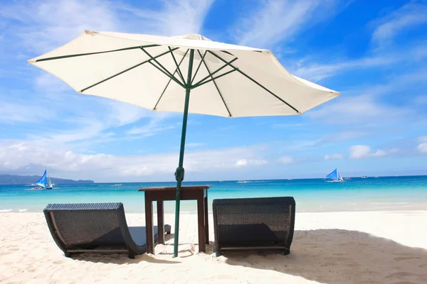 Liegestühle und Sonnenschirm am Sandstrand — Stockfoto