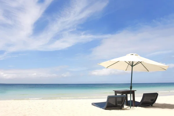 Зонтик и стулья на песчаном пляже — стоковое фото