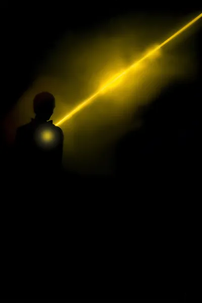 Silhueta humana na fumaça iluminada com raios brilhantes — Fotografia de Stock
